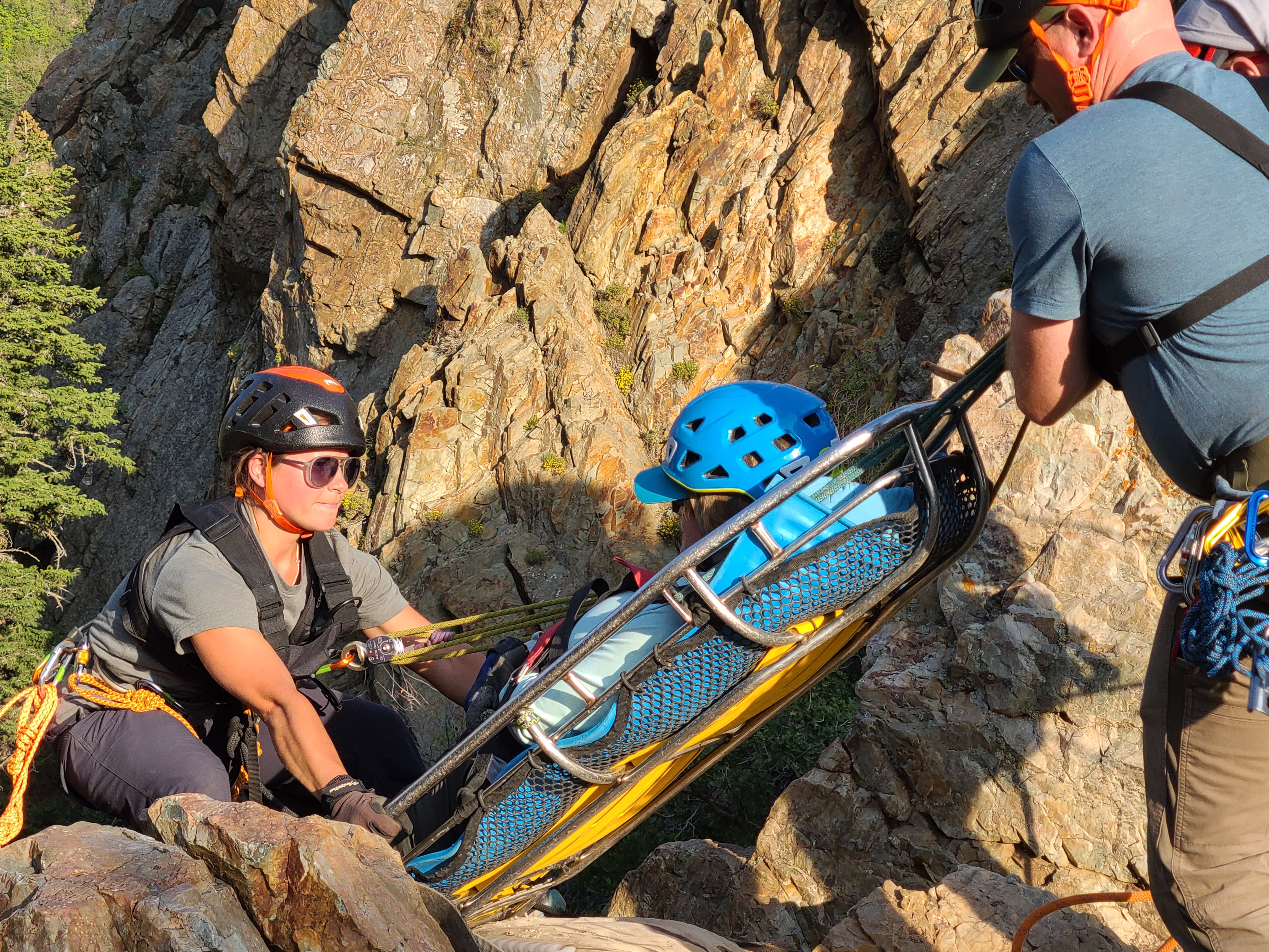 patient being lowered down mountain in litter